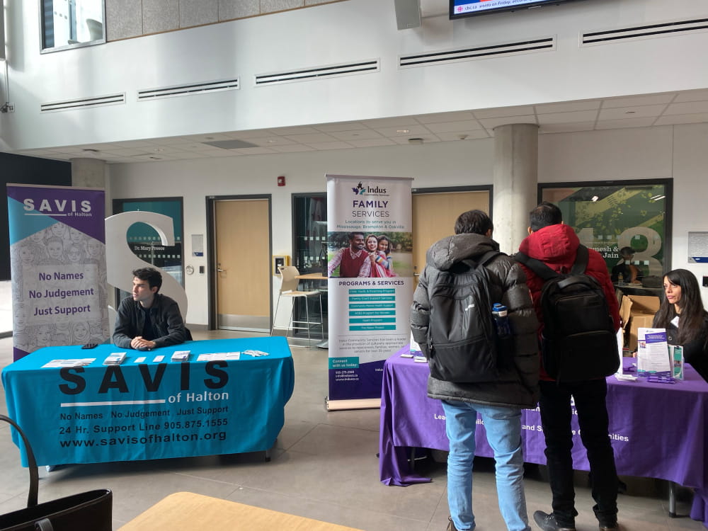 Students interact at a table set up in the HMC marketplace