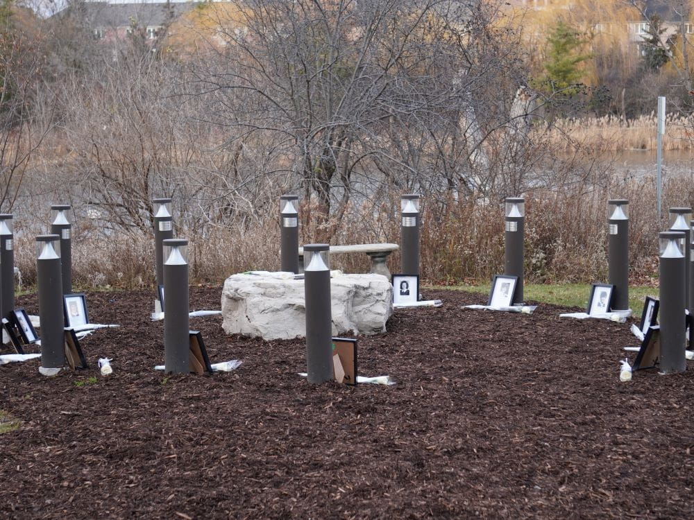 Davis Campus Peace Garden with framed photos and white roses place at the memorial posts