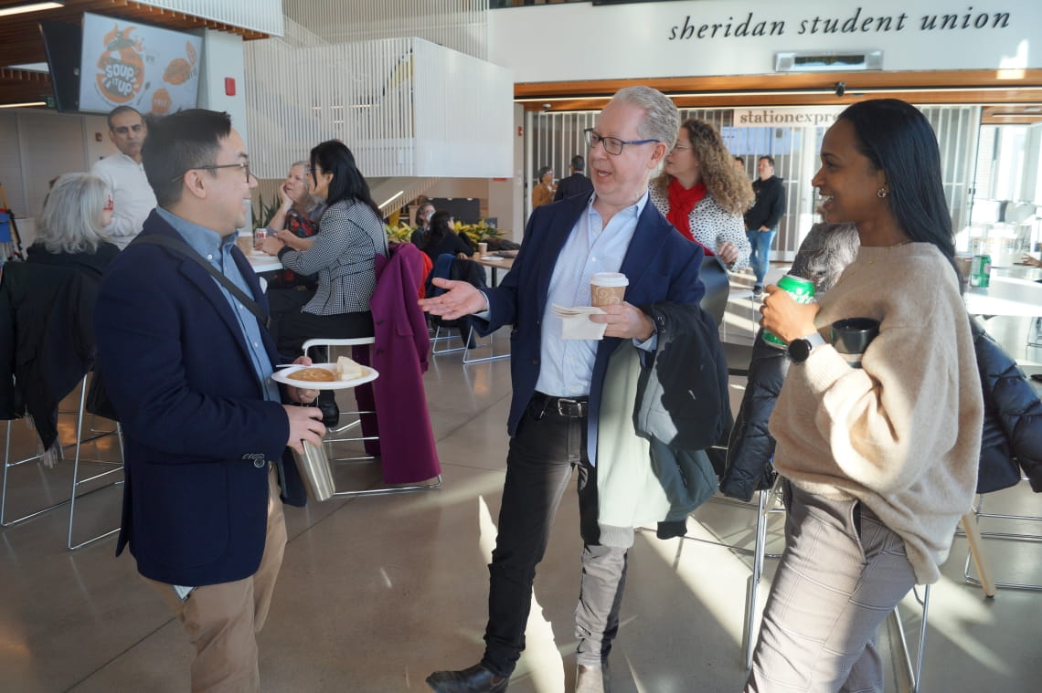 Three people are engaged in an enjoyable conversation