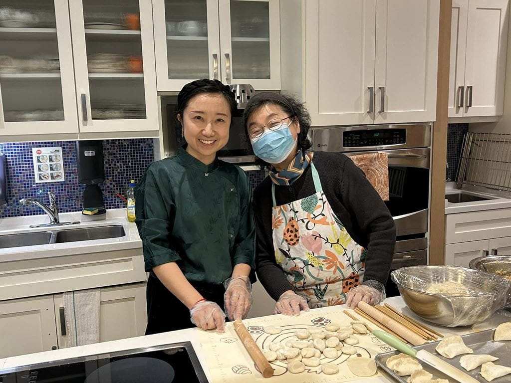 SSW- Gerontology student Bo Li stands with her mother in the kitchen of LaSalle Park Retirement Community, where the two are making dumplings