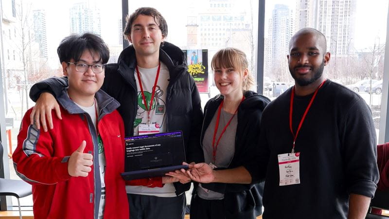 Four students pose with their third place prize