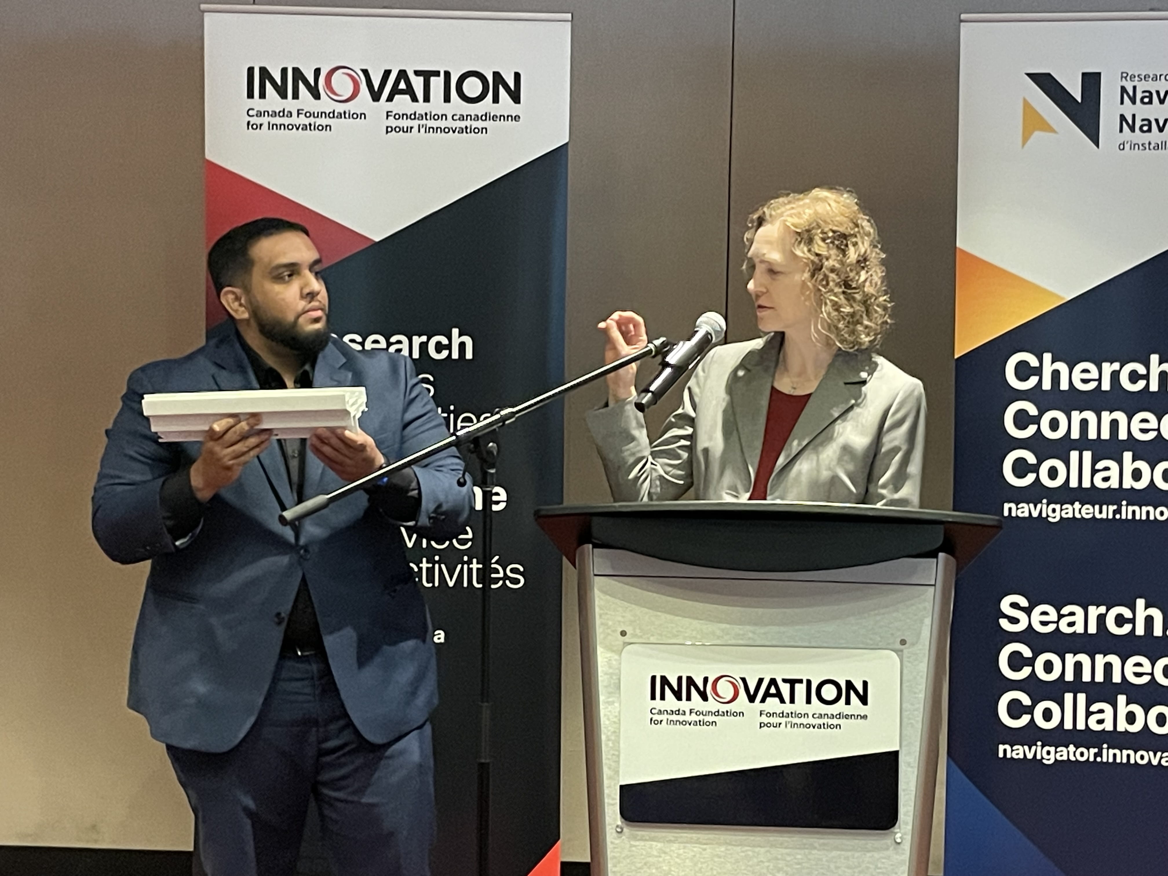 Sheridan research technologist Mohamed Kasim and Generator at Sheridan Director of Research and Innovation Carolyn Moorlag conduct a presentation at the podium during a Canadian Foundation for Innovation event