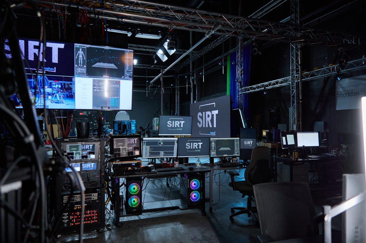 A photo of the Screen Industries Research and Training Centre that contains numerous screens, many of which say SIRT on their wallpaper.
