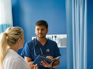 Medical professionals standing in a hospital room and having a discussion