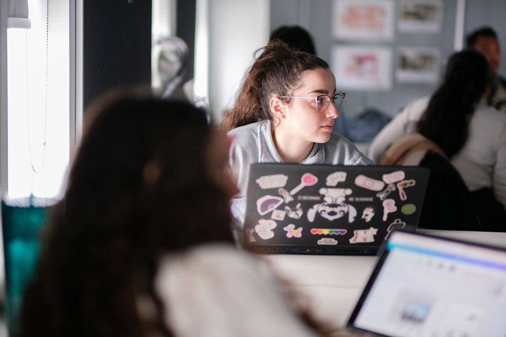 A student with a laptop in a classroom