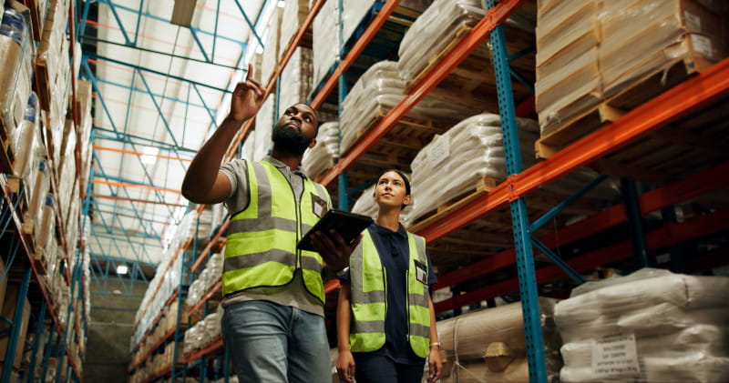 Two people walking through a warehouse