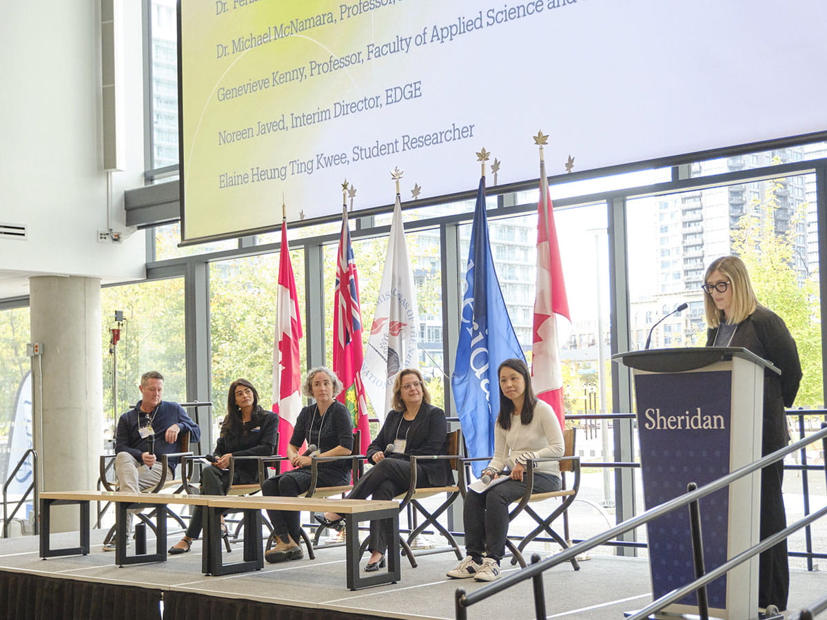 A panel of people sitting side-by-side on a stage