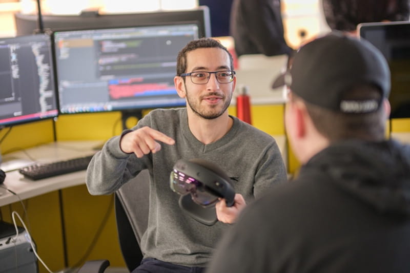 A person holding and pointing to a device