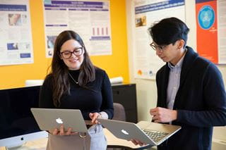Two Sheridan researchers working on laptop computers