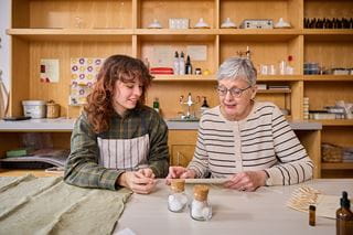 An elderly woman reading with a young woman