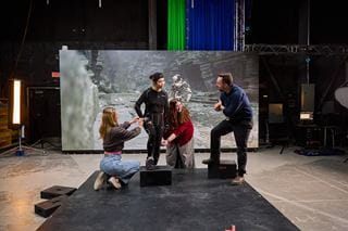 People posing in front of a sound stage