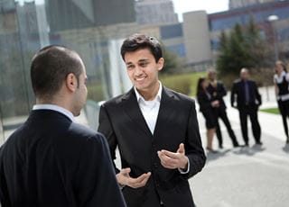 Two men in suits talking outdoors