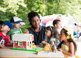 Early childhood education student with kids in a playground
