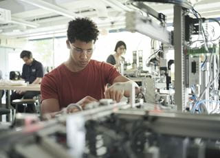 An electronics engineering technology student working in a lab.