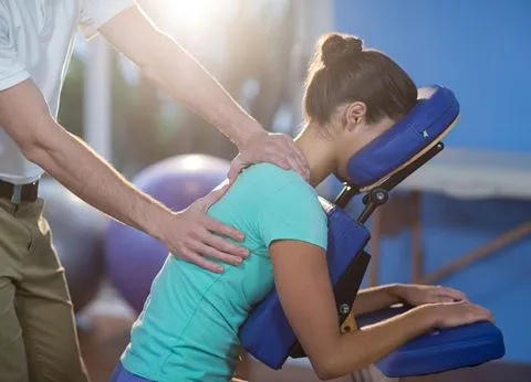 A massage therapist providing manual therapy to a client