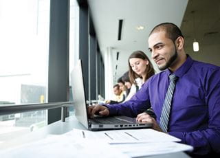 Executive Office Administration student working on a laptop