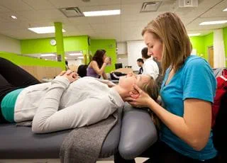 Students practicing manual osteopathic techniques