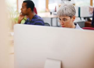 Two people working on computers in an office