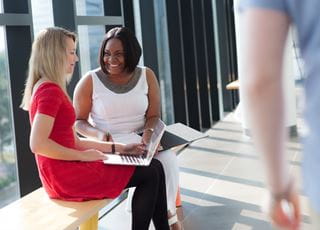 Two women working on a laptop computer