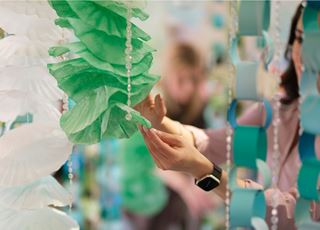 A Visual Merchandising Design student setting up a display window