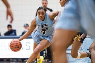 A student athlete dribbling a basketball during a game