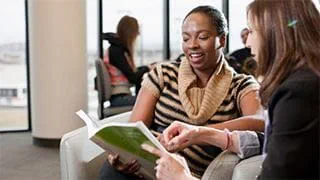 Two students chatting over a book
