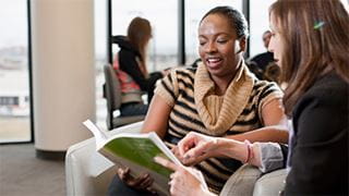 Two students chatting over a book